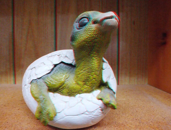 Red, cyan 3D image of a baby dinosaur sculpture.